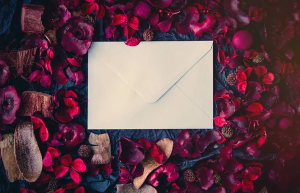 Пелюстки троянд і теперішній конверт — стокове фото