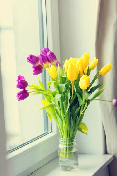 Тюльпаны в стеклянной банке — стоковое фото