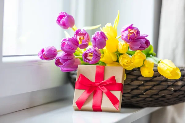 Купа тюльпанів і подарунок на підвіконні — стокове фото