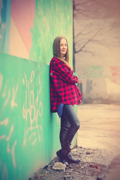 Mooi meisje in de buurt van graffiti muur — Stockfoto