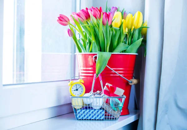 Tulipes dans seau, cadeaux, réveil — Photo