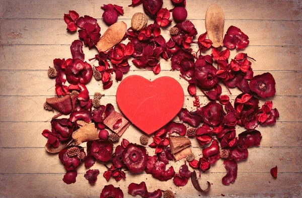 Corazón rojo y pétalos florales rojos — Foto de Stock