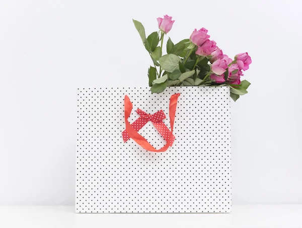 Pink roses in dotted shopping bag — Stock Photo, Image