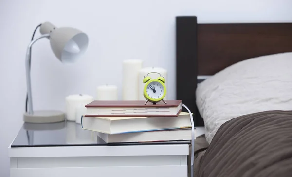 Tisch neben Bett im gemütlichen Schlafzimmer — Stockfoto