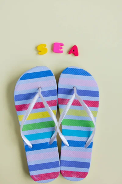 Zdjęcie kolorowe sandały na plaży i litery na Znakomity — Zdjęcie stockowe
