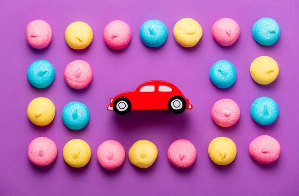Foto de sabrosos malvaviscos coloridos y juguete en forma de coche en la w — Foto de Stock