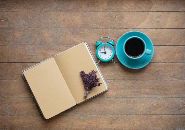 Foto de notebook aberto, monte de lavanda, despertador e xícara — Fotografia de Stock