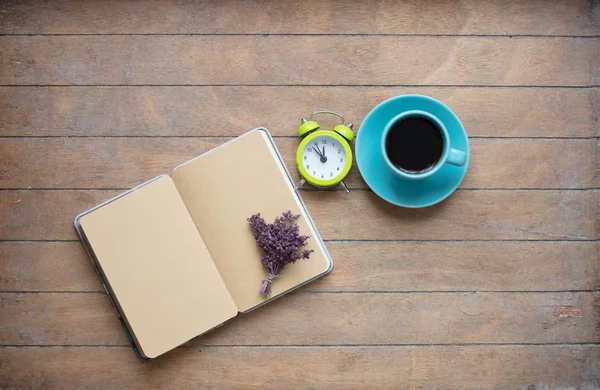 Foto de notebook aberto, monte de lavanda, despertador e xícara — Fotografia de Stock