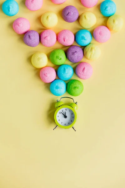 Foto von leckeren bunten Marshmallows und Wecker auf dem Teich — Stockfoto