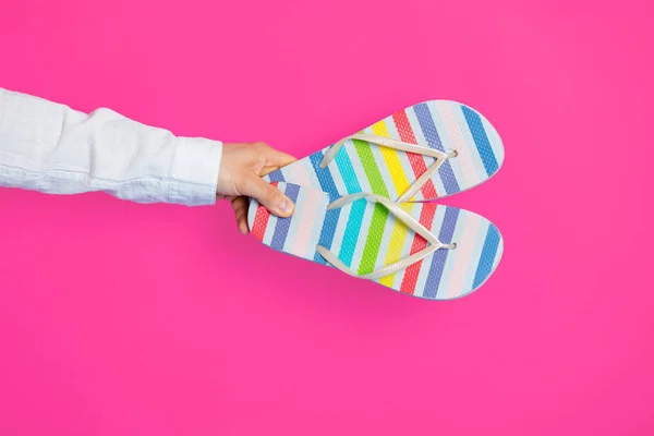 Ręka trzyma kolorowe sandały — Zdjęcie stockowe