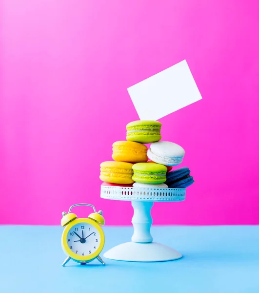 Macarrones en soporte con reloj despertador vintage — Foto de Stock