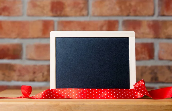 Blank blackboard on wooden table — Stock Photo, Image