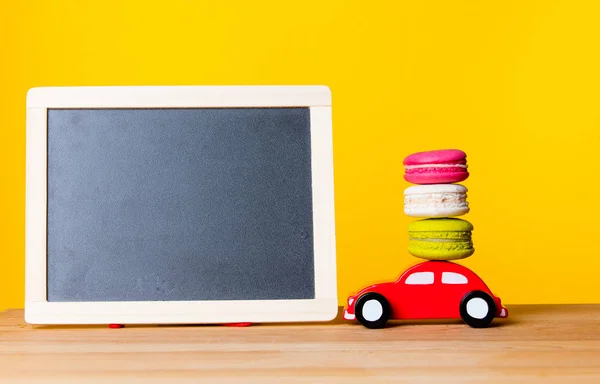 Carro de brinquedo transportando macarons — Fotografia de Stock