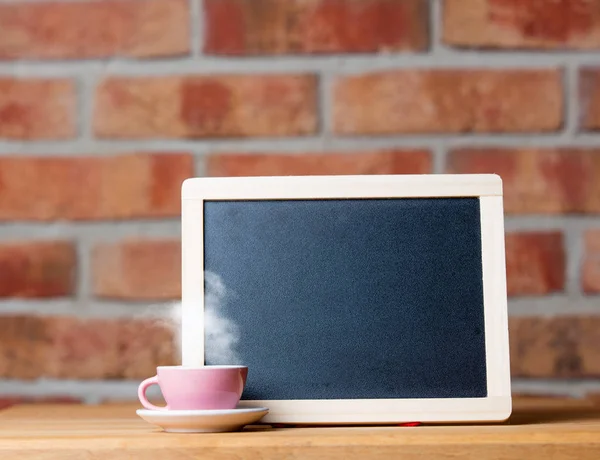 Blank blackboard on wooden table — Stock Photo, Image