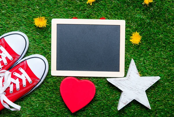 Red gumshoes and blank blackboard — Stock Photo, Image