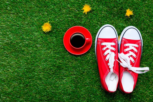 Red gumshoes and cup of coffee — Stock Photo, Image