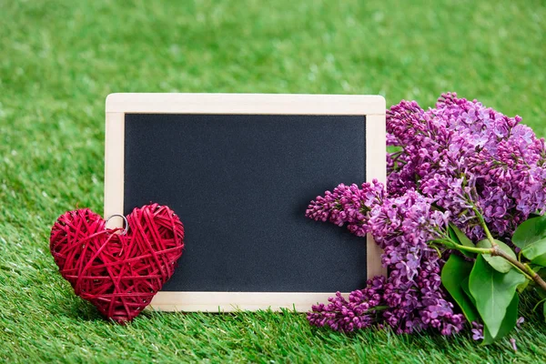Blackboard and lilac flowers — Stock Photo, Image