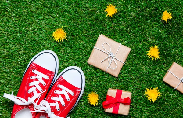 Red sporty gumshoes and gift boxes — Stock Photo, Image