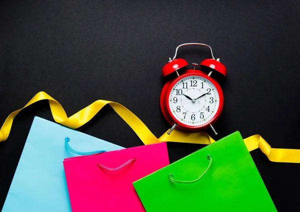 Sacos de compras com relógio e fita — Fotografia de Stock