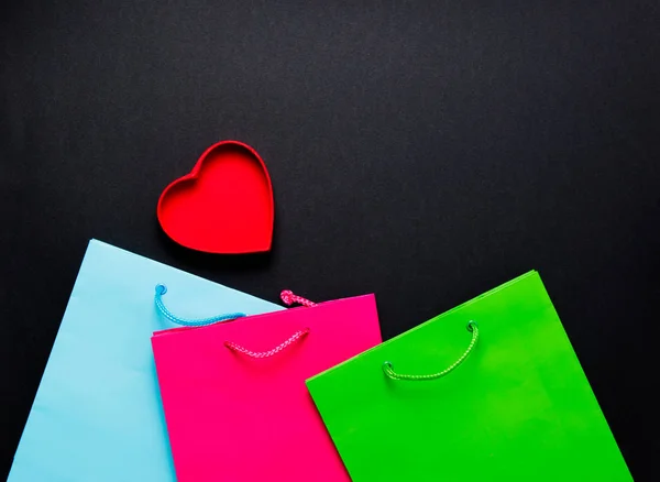 Corazón rojo con coloridas bolsas de compras —  Fotos de Stock