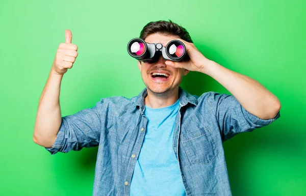 Jovem homem sorridente com binocular — Fotografia de Stock