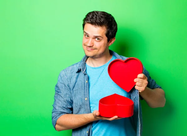 Pohledný muž s srdce tvar krabice dárkové — Stock fotografie