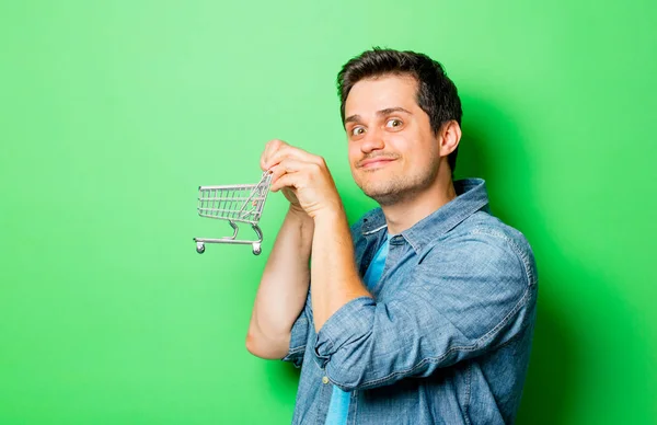 Jovem sorridente homem com carrinho — Fotografia de Stock