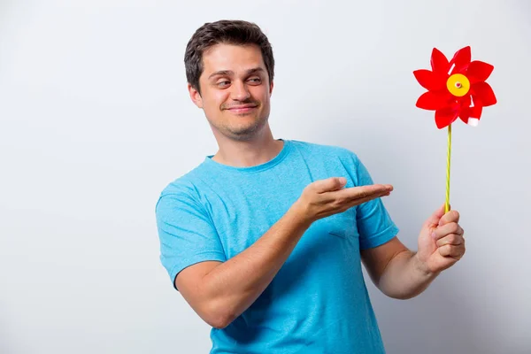 Man in blauw t-shirt met rood pinwheel speelgoed — Stockfoto
