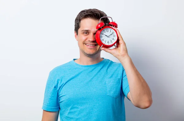 Portret van een jonge man met wekker glimlachen — Stockfoto