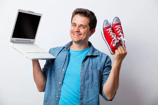 Homem de t-shirt azul com gomas vermelhas e laptop — Fotografia de Stock