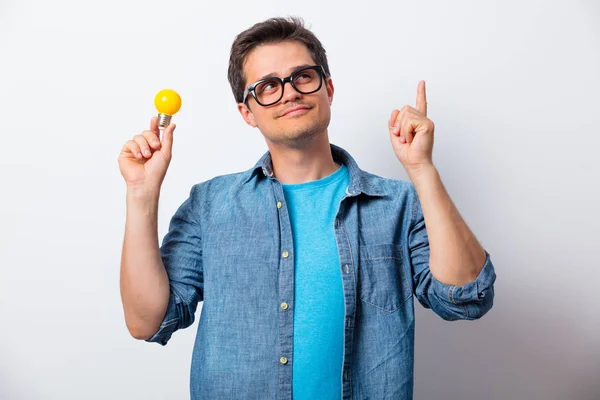 Giovane uomo in camicia in possesso di lampadina — Foto Stock