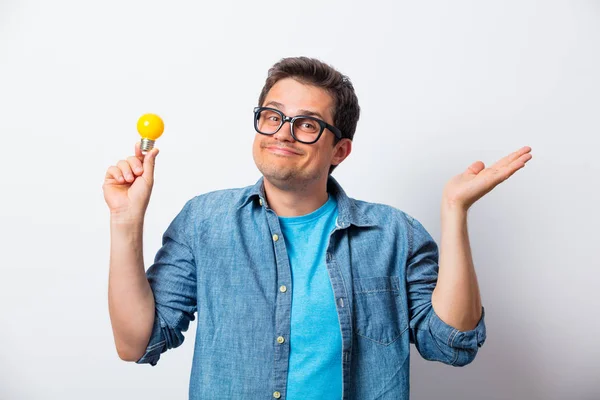 Giovane uomo in camicia in possesso di lampadina — Foto Stock