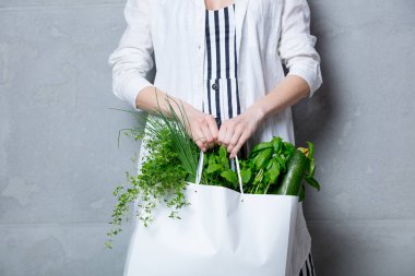 otlar ile beyaz çanta tutan kadın