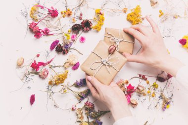 Hediye kutuları otlar ile tutan eller