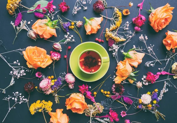 Травы и цветы с чашкой чая — стоковое фото