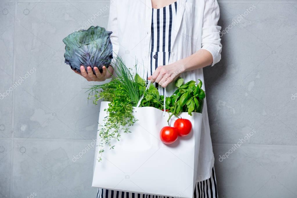 woman holding bag with vegetables
