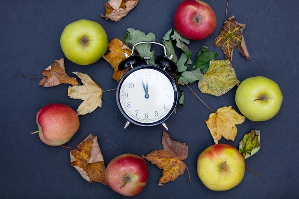 Apples and leaves with retro alarm clock — Stock Photo, Image