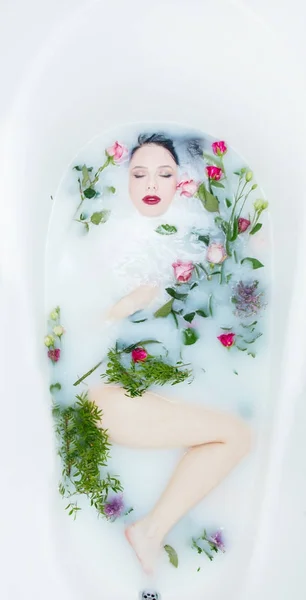 泡のお風呂にバラの花を持つ女性 — ストック写真