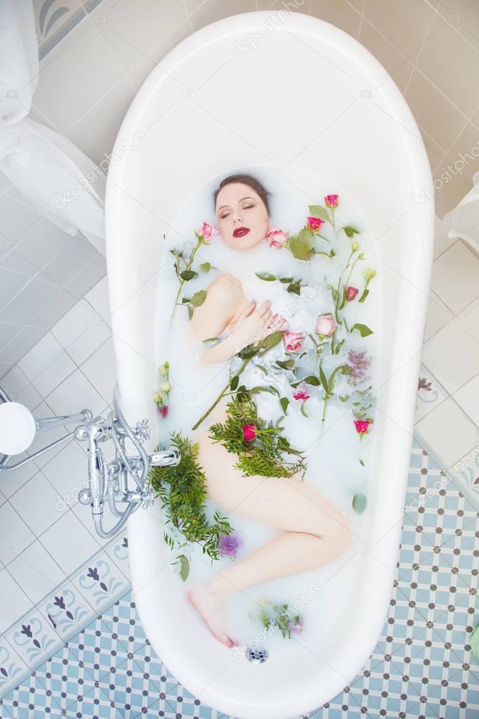 Woman with rose flowers in the foam bath