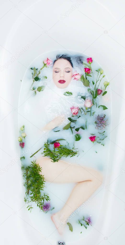 Woman with rose flowers in the foam bath