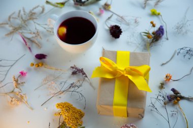 Beyaz hediye kutusu ve otlar ile kırmızı çay fincan