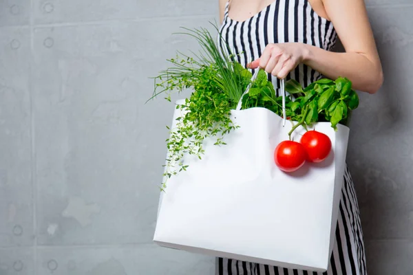 Női gazdaság táska, gyógynövények és paradicsommal — Stock Fotó