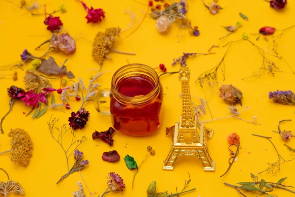 Xícara de chá vermelho com lembrança Torre Eiffel e ervas — Fotografia de Stock
