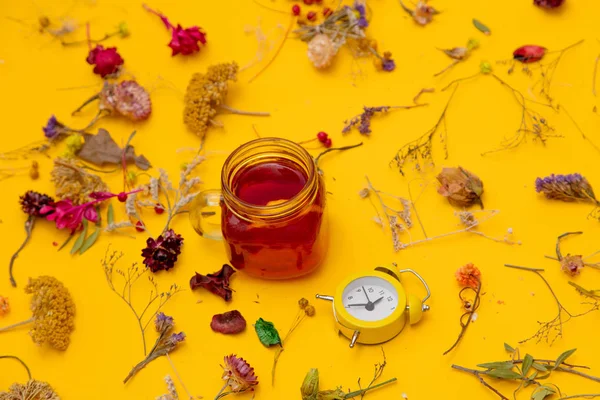 Küçük çalar saat ve otlar ile kırmızı çay — Stok fotoğraf