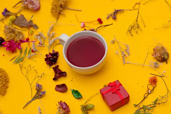 Kopje rode thee met luxe-geschenketui en kruiden met bloemen — Stockfoto