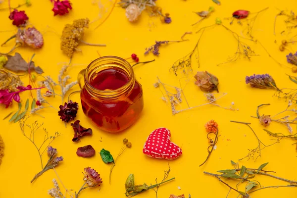 Kırmızı çay kalp şekli oyuncak ve otlar ile — Stok fotoğraf