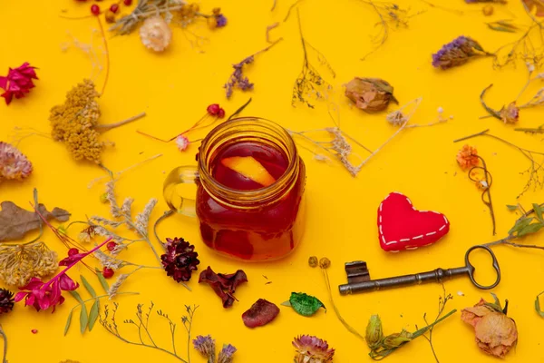 Taza de té rojo con forma de corazón y llave vintage y hierbas —  Fotos de Stock