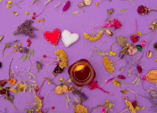 Taza de té con juguetes en forma de corazón y hierbas — Foto de Stock