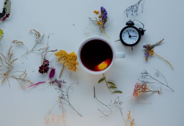 Beyaz küçük çalar saat ile kırmızı çay fincan 