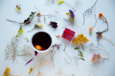 Beyaz hediye kutusu ve otlar ile kırmızı çay fincan